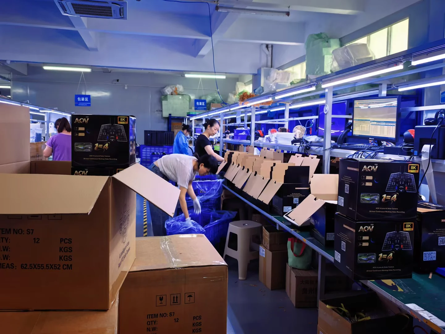 Team members packing camera products at the factory