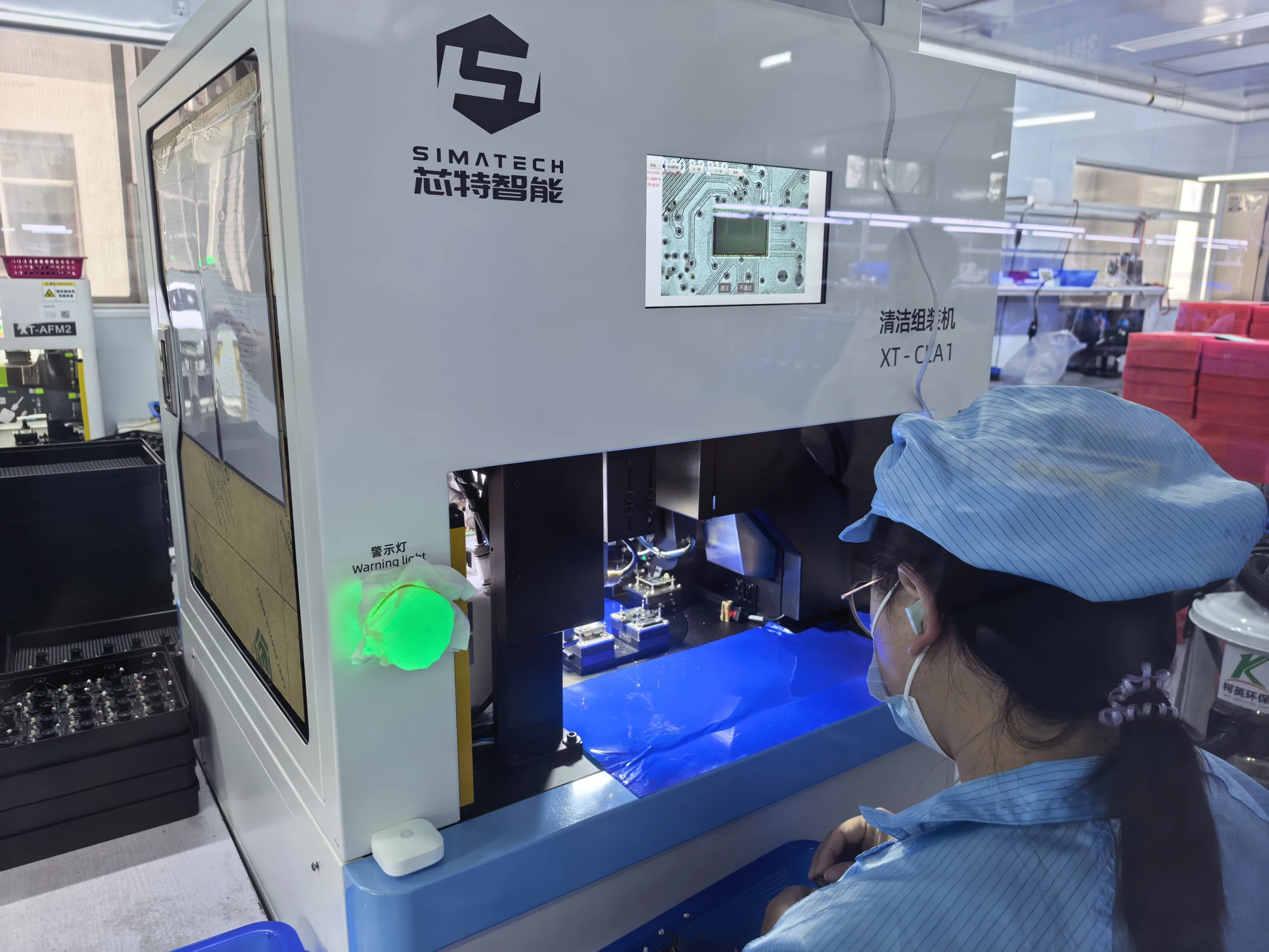Technician operating production equipment in the camera factory